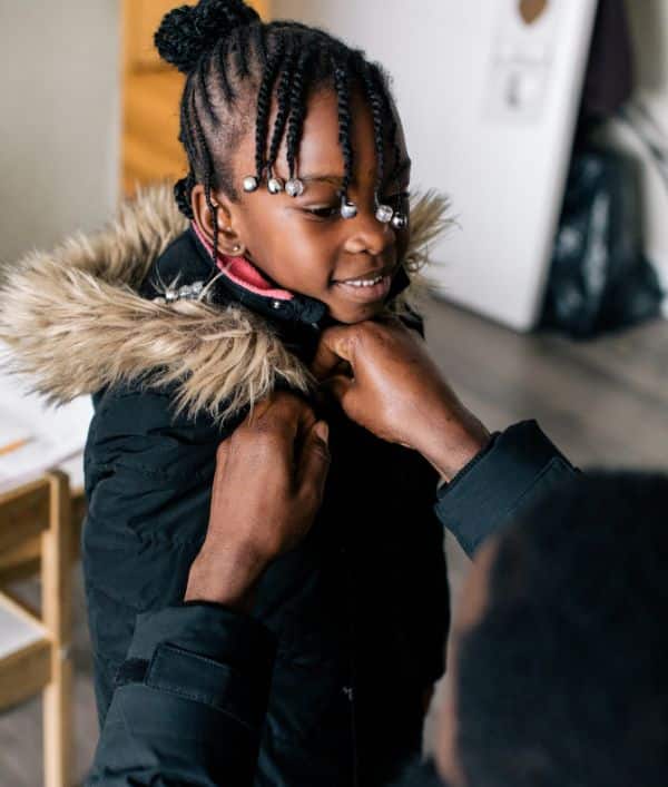 Smiling young girl receives brand-new winter coat 